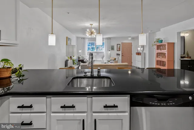 a kitchen with stainless steel appliances granite countertop a sink a stove and a wooden cabinets