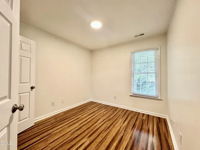 a view of a room with wooden floor and fan