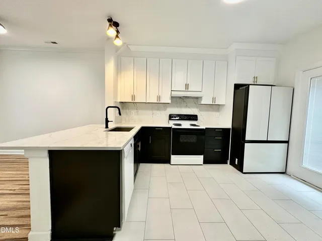 a kitchen with a sink a refrigerator and cabinets