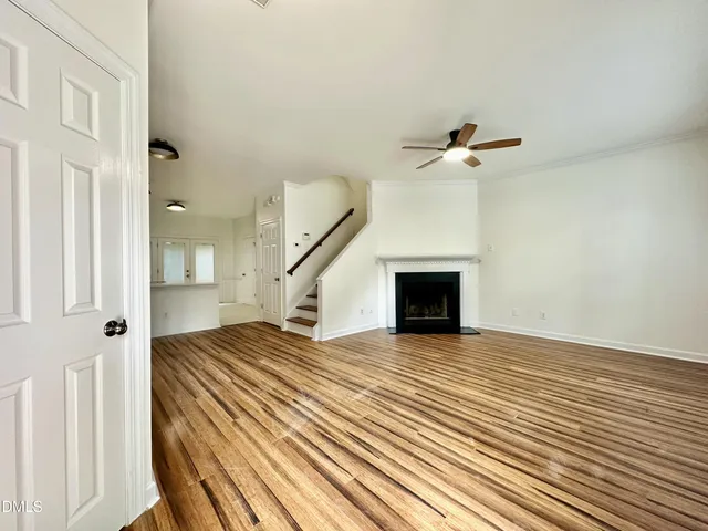 a view of a livingroom with wooden floor and a ceiling fan
