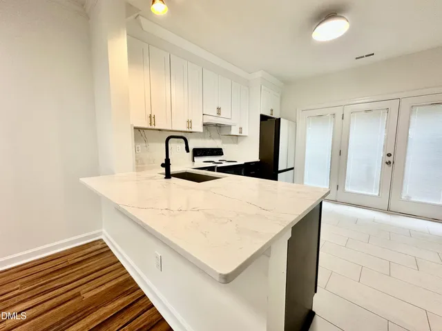 a kitchen with a sink a stove and cabinets