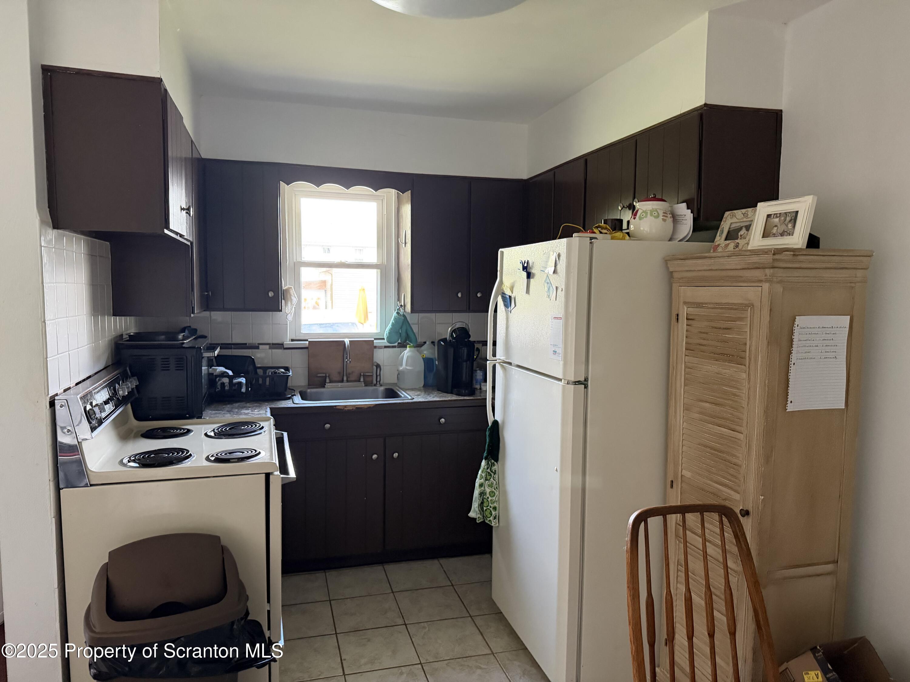 612 Oak Street Old Forge, PA 18518 - Photo 16 of 17 a kitchen with a refrigerator a stove a sink a washer and dryer