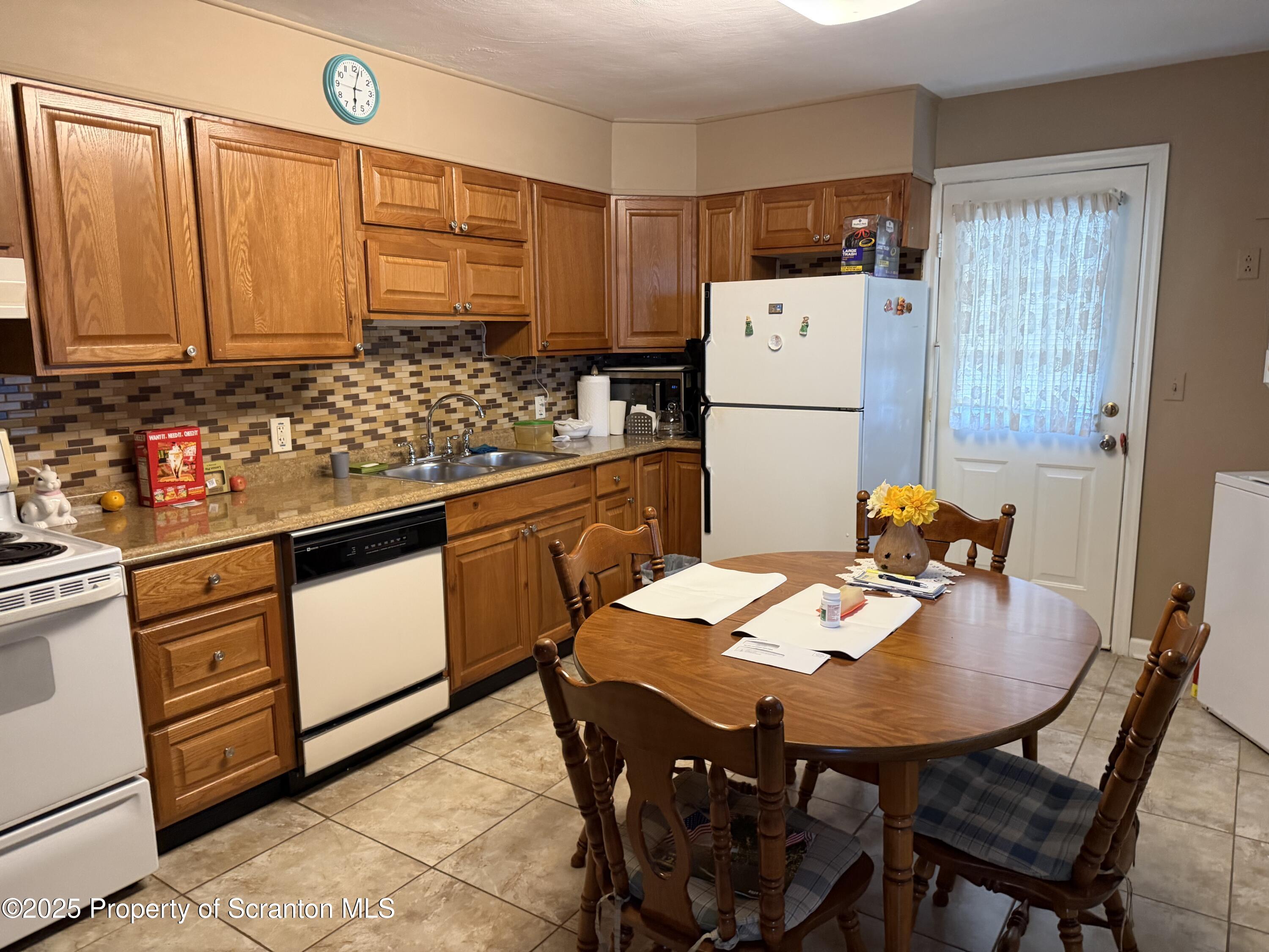612 Oak Street Old Forge, PA 18518 - Photo 5 of 17 a kitchen with stainless steel appliances kitchen island granite countertop a table chairs and a refrigerator