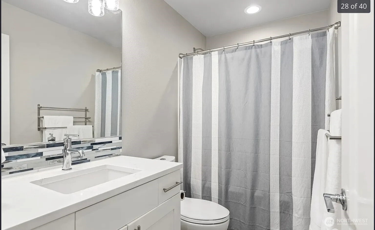22823 23rd Avenue Southeast, Unit 8 Bothell, WA 98021 - Photo 13 of 17 a bathroom with a sink a toilet a mirror and shower curtain