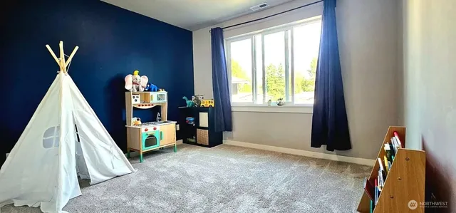 a view of a bedroom with furniture and a window