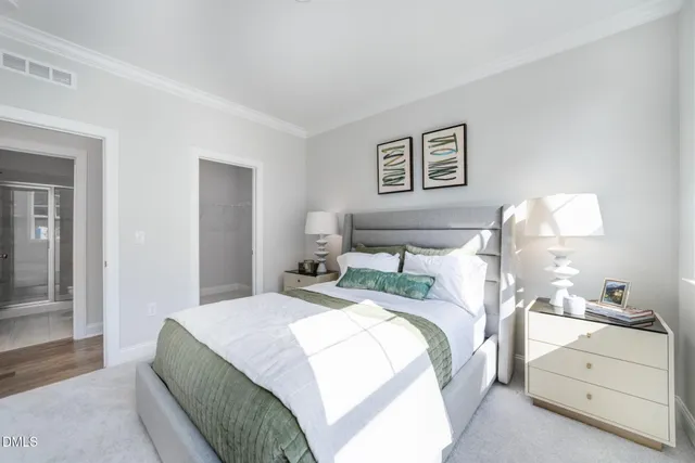 a bedroom with a bed and a lamp on dresser