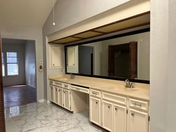 a bathroom with a granite countertop sink and a mirror