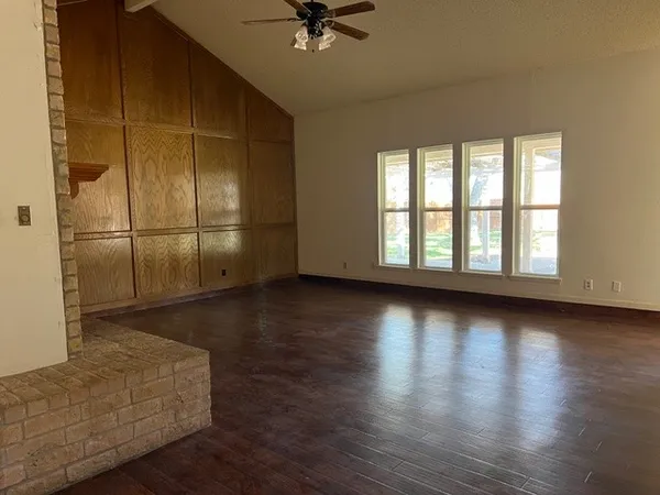 a view of a livingroom with wooden floor and a ceiling fan