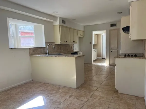 a view of a kitchen with a sink and a refrigerator