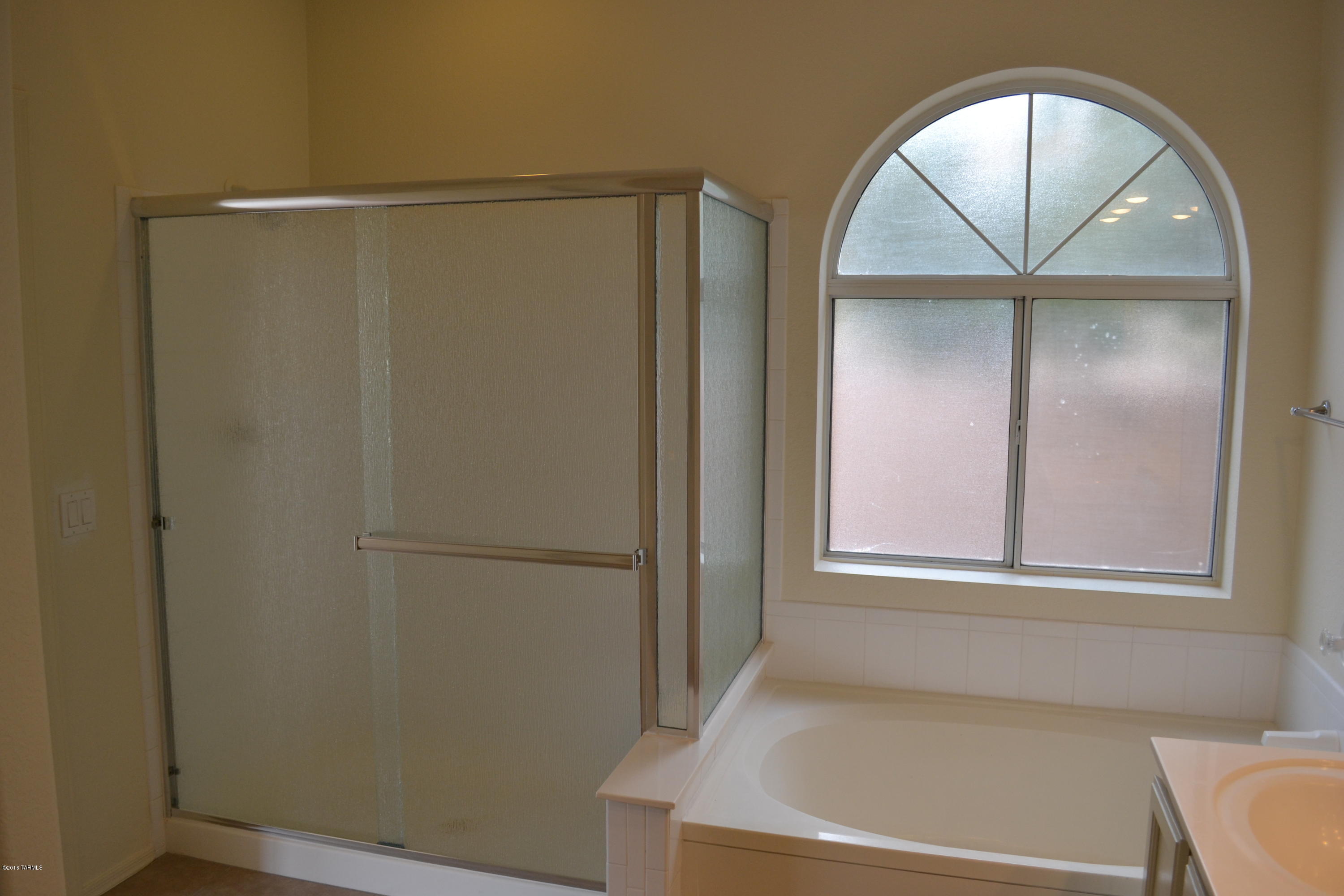5640 North Cherokee Ridge Road Tucson, AZ 85750 - Photo 16 of 39 a view of an empty room with wooden floor and a window
