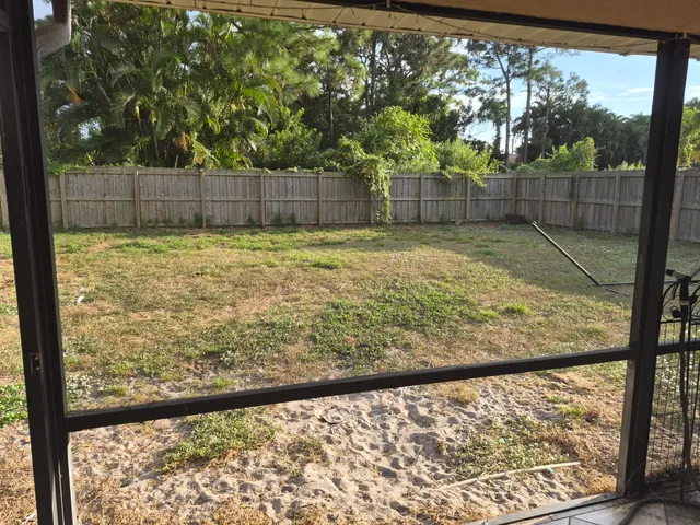 a view of a room with a large tree and wooden fence