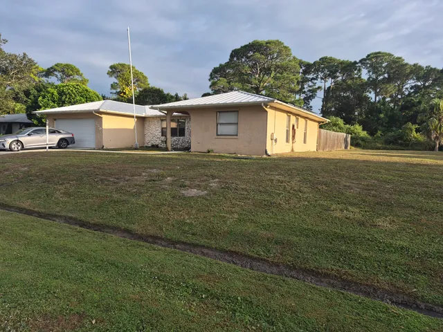 a front view of house with yard and trees