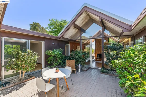 a backyard of a house with a table and chairs