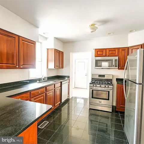 a kitchen with stainless steel appliances a stove a refrigerator and a sink