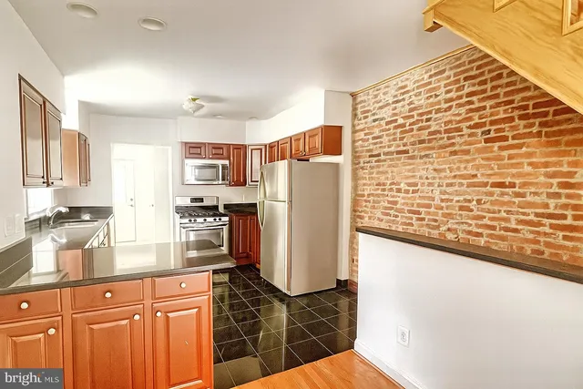 a kitchen with stainless steel appliances granite countertop a refrigerator and a stove top oven