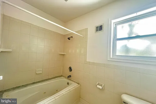 a bathroom with a bathtub window and a shower