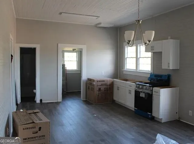 a kitchen with a stove and a wooden floor