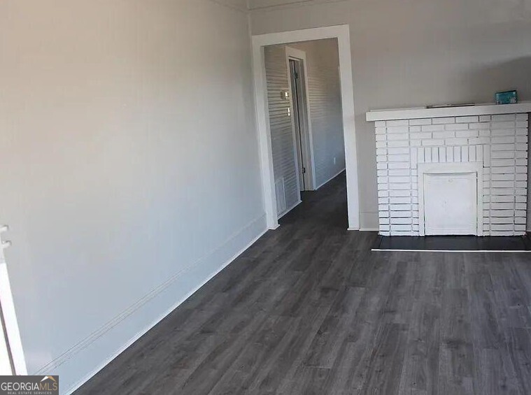 824-828 South Broad Street Commerce, GA 30529 - Photo 5 of 17 a view of an empty room with wooden floor and a window