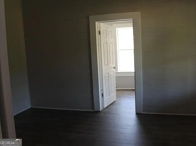 a view of an empty room and wooden floor and a window