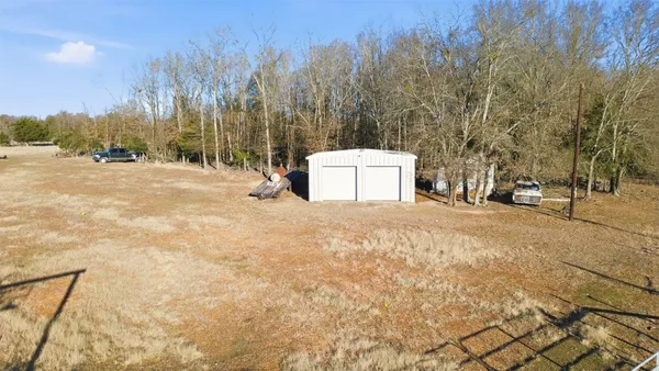 a view of a dry yard with wooden fence