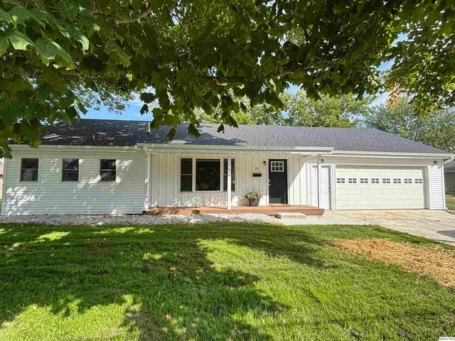 a front view of a house with a garden and yard