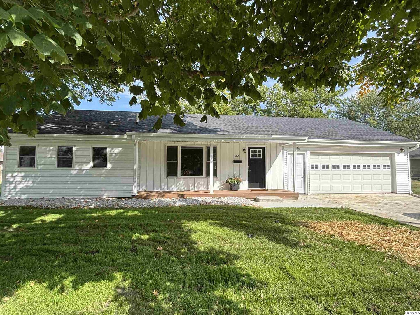 a front view of a house with a garden and yard