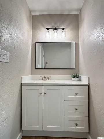 a bathroom with a sink vanity and mirror