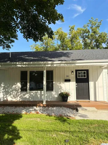 a front view of a house with a yard garage and outdoor seating