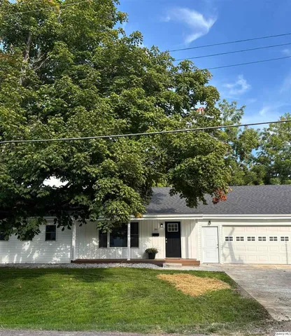 a view of house with swimming pool and yard