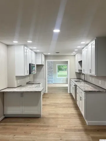 a large kitchen with kitchen island a sink stainless steel appliances and cabinets
