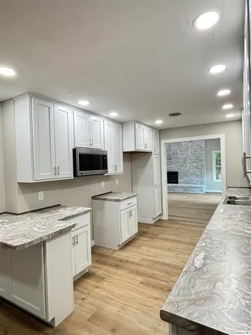 a large kitchen with stainless steel appliances granite countertop a stove a sink and a granite counter tops