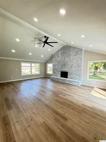 an empty room with wooden floor and fireplace
