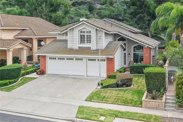a front view of a house with a yard and potted plants