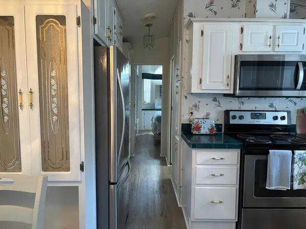 a kitchen with stainless steel appliances granite countertop a refrigerator and a stove top oven
