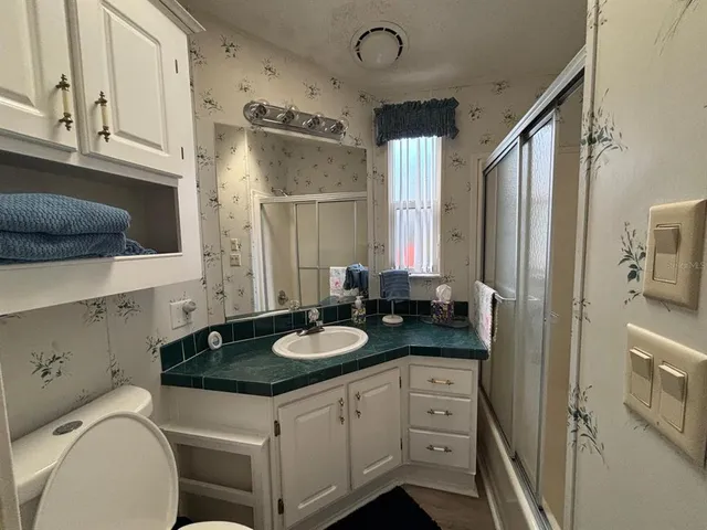 a bathroom with a granite countertop sink toilet and shower