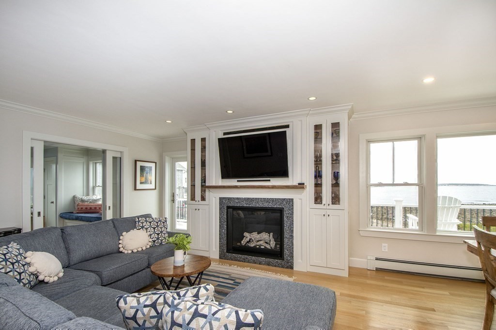61 Seaside Road Scituate, MA 02066 - Photo 16 of 39 a living room with furniture a flat screen tv and a fireplace