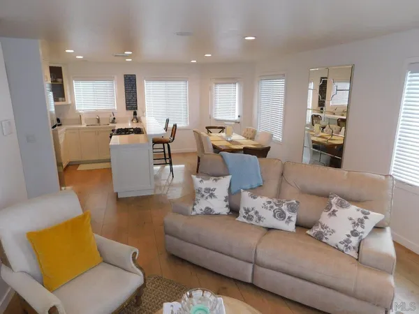a living room with furniture kitchen and a table