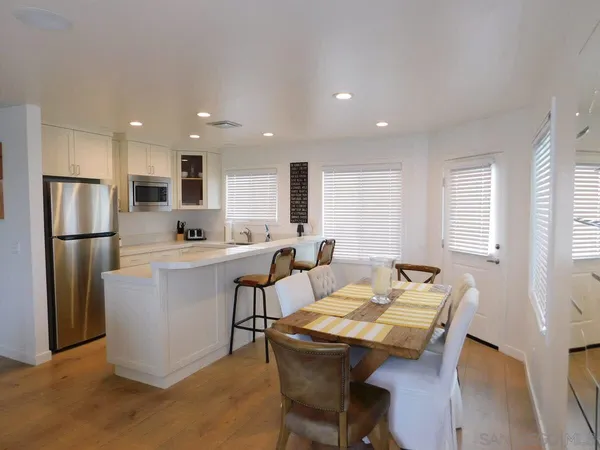 a kitchen with a table chairs refrigerator and microwave