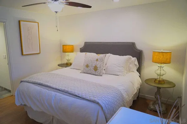 a bedroom with a bed and wooden floor