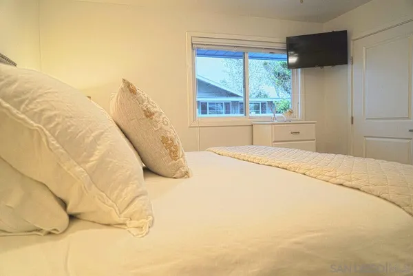 a bed sitting in a bedroom next to a window
