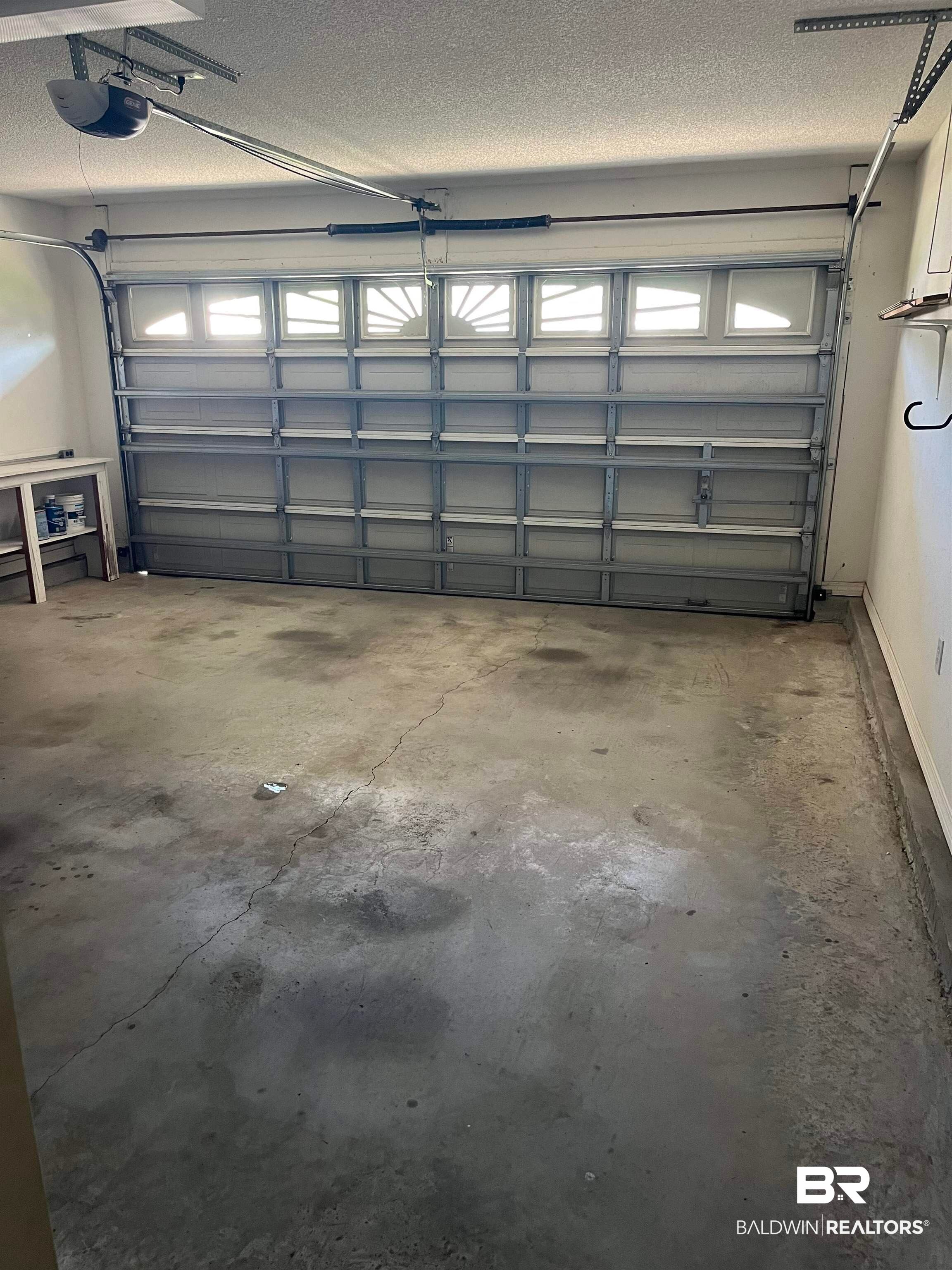 309 Cluster Street Foley, AL 36535 - Photo 30 of 38 Garage featuring a sectional overhead door with window inserts, concrete flooring, and an automatic opener system