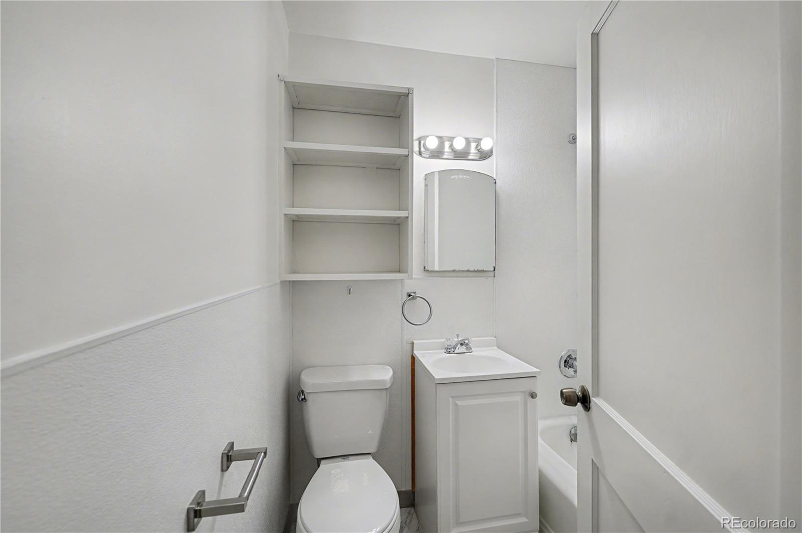 620 Strong Street, Unit 3 Brighton, CO 80601 - Photo 7 of 9 a bathroom with a toilet sink and vanity
