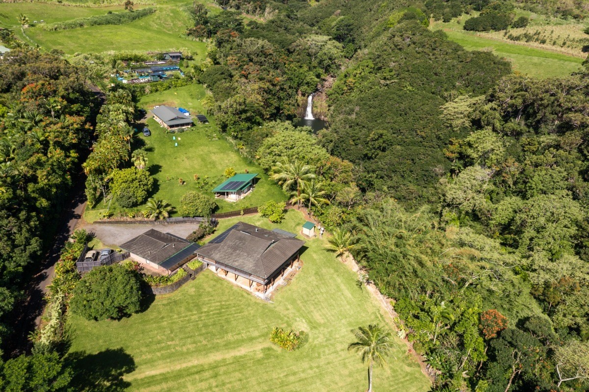 an aerial view of residential house with swimming pool and green space