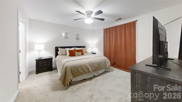 a bedroom with a large bed and a chandelier