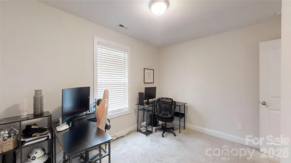 a view of a workspace with furniture and a window