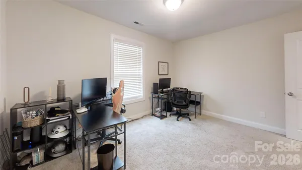 a view of a workspace with furniture and a window