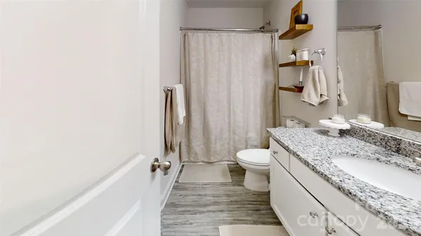 a bathroom with a granite countertop sink toilet and shower