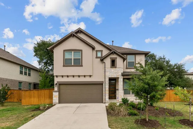 a front view of house with yard and trees in the background