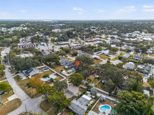 an aerial view of residential houses with outdoor space and trees