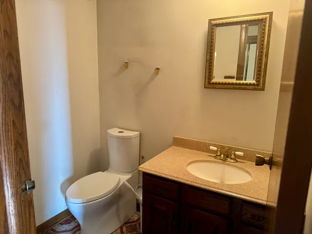 a bathroom with a sink and mirror with toilet